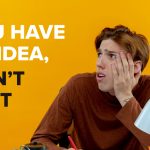 A young man with a worried expression, sitting at a desk against a bright orange background, accompanied by the text, "You have an idea, don't wait."